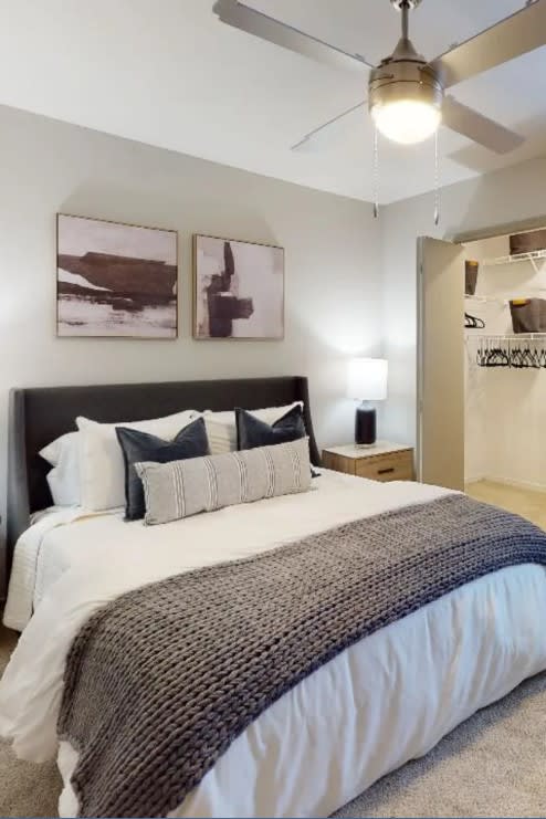 a bedroom with a bed and a ceiling fan