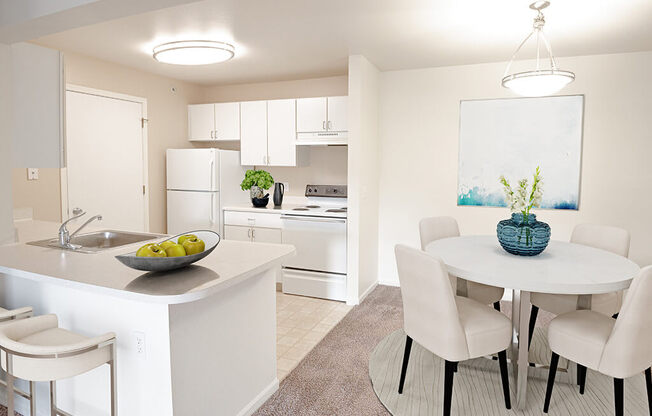 A kitchen with a table and chairs.