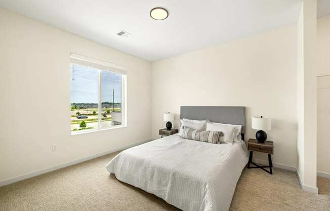 a bedroom with a large bed and a window at The Standard on 32nd, West Fargo, ND, 58078