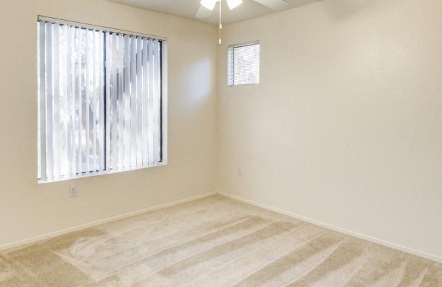 Ingleside Apartments bedroom with wall to wall carpet, a ceiling fan, and large window