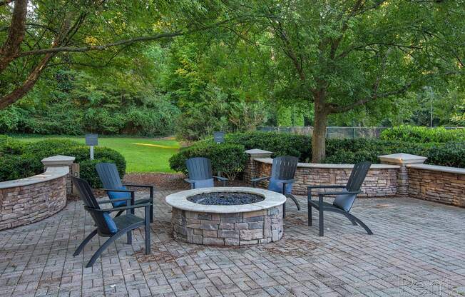 a patio with a fire pit and chairs