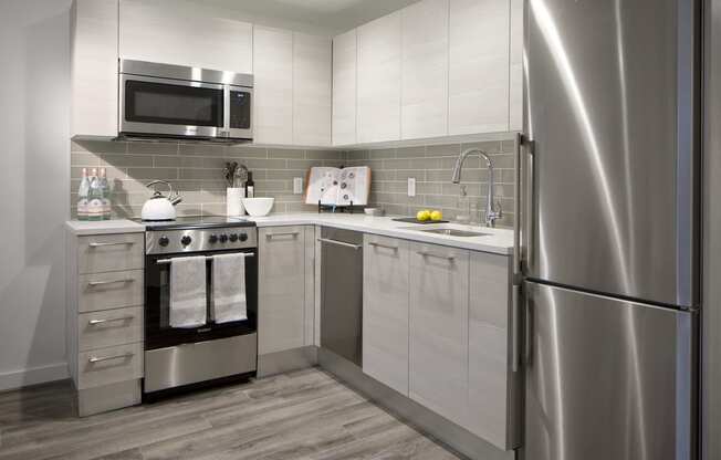 a small kitchen with stainless steel appliances and white cabinets