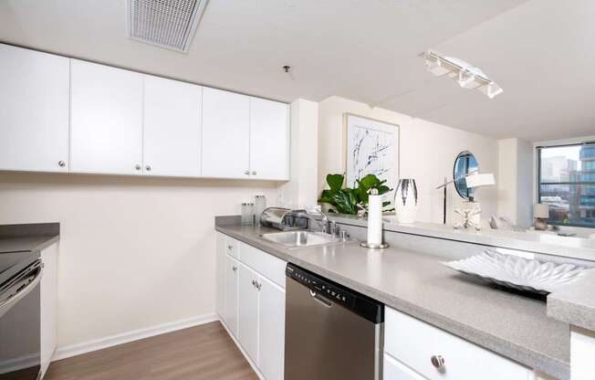 A kitchen with white cabinets and a grey countertop.