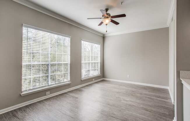 Apartments for Rent Houston - Open-Concept Living Room with Wood Flooring, Two Large Windows, and a Ceiling Fan