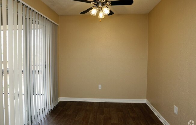 a living room with a ceiling fan and a window