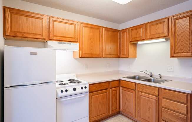 a kitchen with white appliances and wooden cabinets. Eagan, MN Glen Pond Apartments