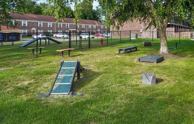 A playground with a green slide and a red fire hydrant.