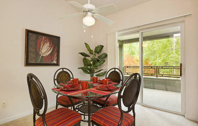 a dining room with a table and chairs in front of a window