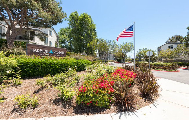 an flag is flying in front of the pointe apartments sign