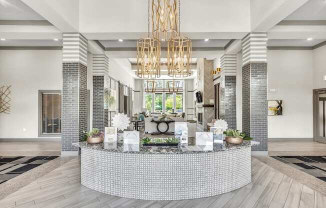 Reception area with a white reception desk and a large chandelier at Sterling Creek at Richmond Hill, Georgia , 31324
