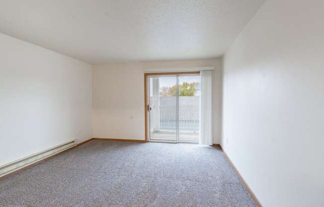 a living room with a glass sliding door. Fargo, ND Oxford Apartments