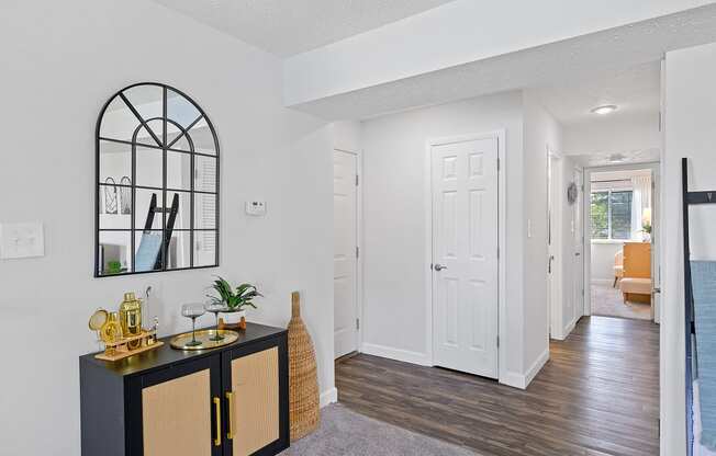 a living room and hallway with a black cabinet and a white door