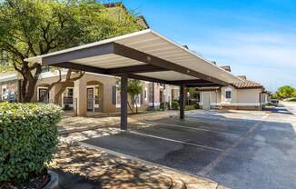 a covered parking lot with a building in the background