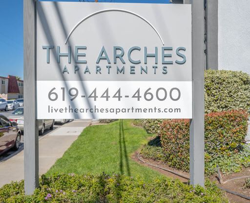 a sign for the arches apartments on the side of a street at The Arches Apartments, El Cajon, CA