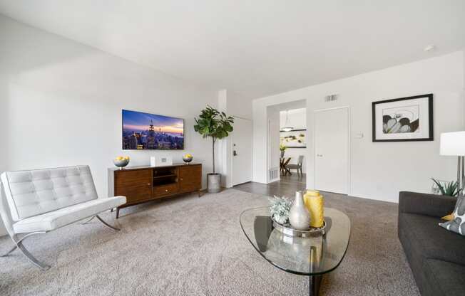 a living room with white walls and carpet