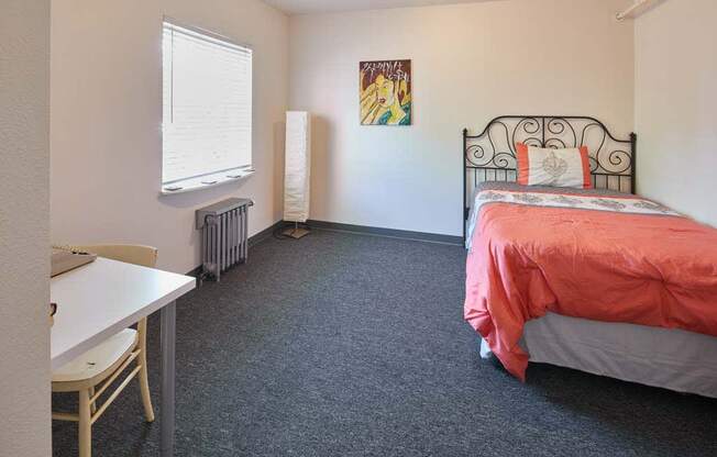 a bedroom with a bed and a desk at MILEPOST 5 Apartments, PORTLAND, 97213