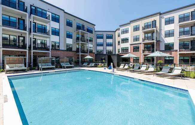 A swimming pool in front of apartment buildings.