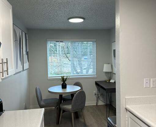 A kitchen with a table and chairs.