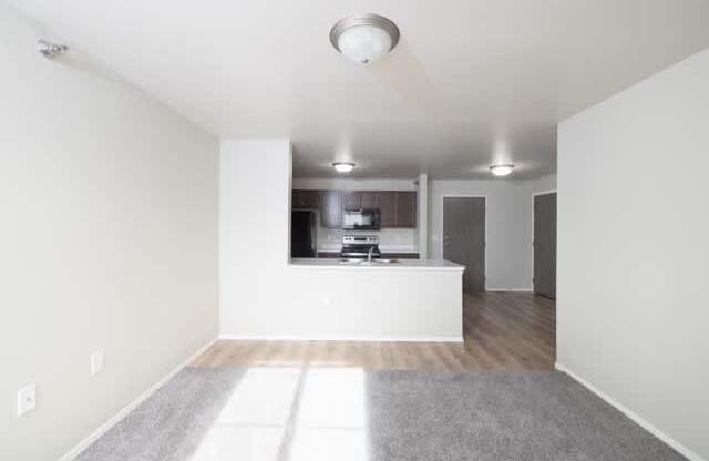 A white room with a grey carpet and a window.