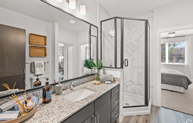 A bathroom with a sink, mirror, and shower. at Aurora Watson Branch, Texas