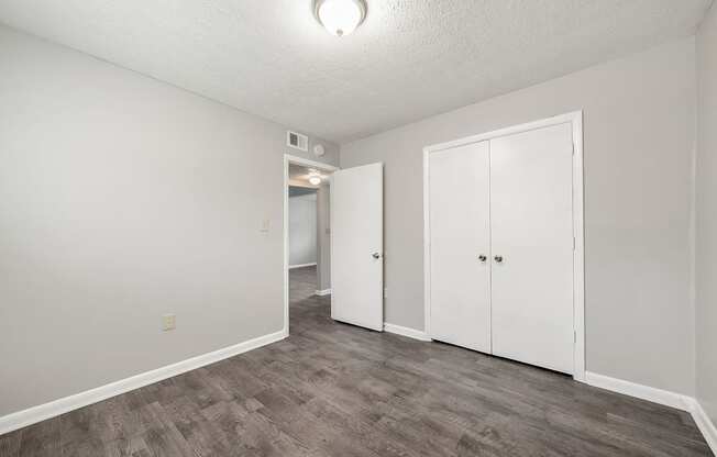 an empty living room with white walls and wood flooring
