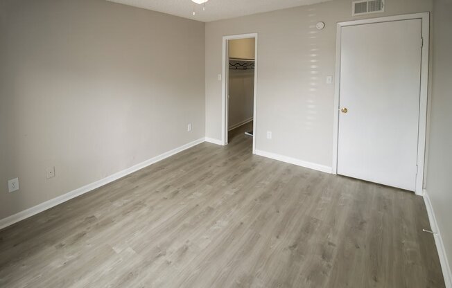 a living room with wood flooring and a door to a hallway