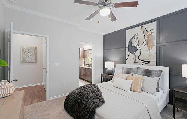 A bedroom with a large bed and a ceiling fan.