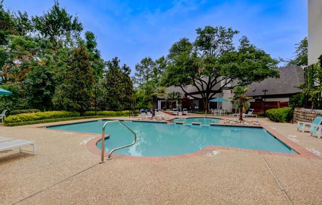 a swimming pool with trees and a building in the background