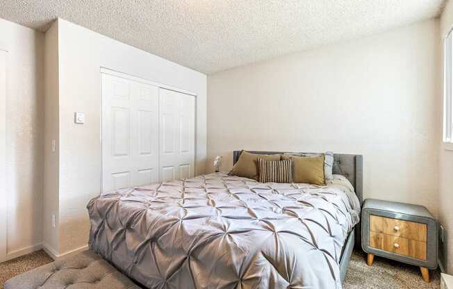 A bedroom with a bed, nightstand, and a door at Wildflower in Kennewick, WA..