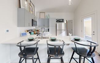 a kitchen with a white counter top and three stools