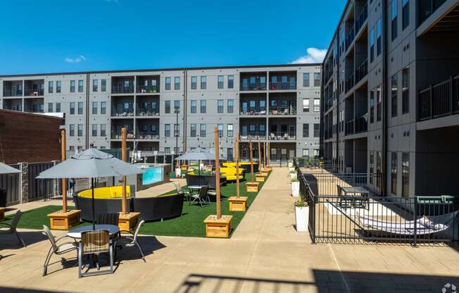 a view of the courtyard of an apartment building with tables and chairs