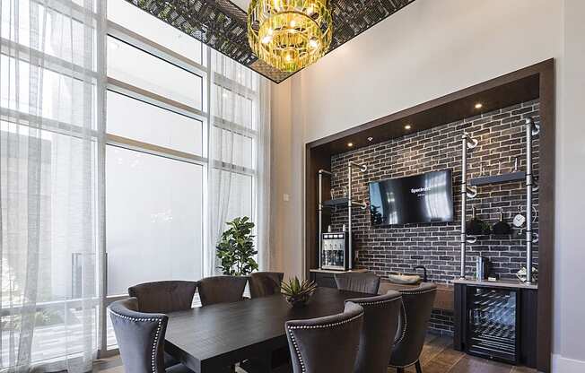 Wine tasting room with wine chandelier, tv, and table with chairs at Residences at The Green in Lakewood Ranch, FL