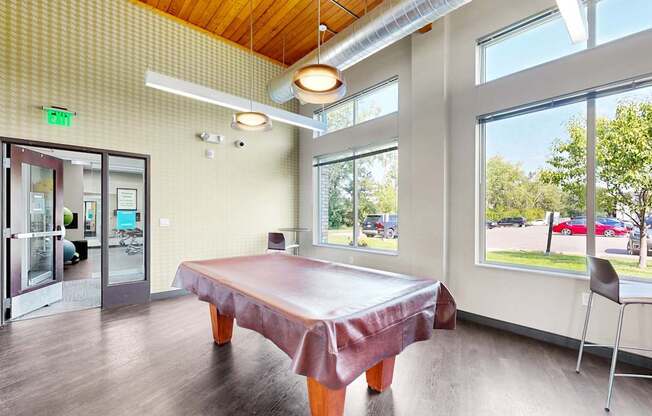 A room with a table and chairs and a view of the outside.