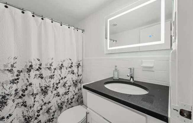 A Bathroom With a Floral Shower Curtain at Ashlawn at Southern Towers, Alexandria, 22311