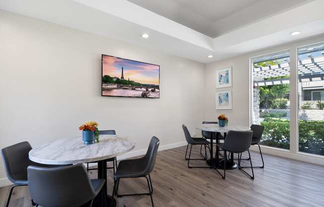 a dining room with a table and chairs and a large window