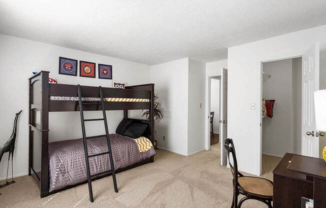 a bedroom with a bunk bed and a desk