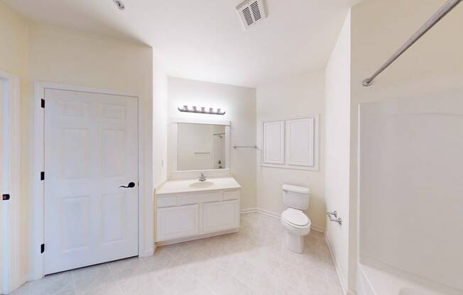 A white bathroom with a toilet, sink, and mirror.