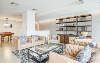 a living room with couches and a glass coffee table