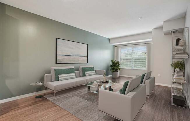 A living room with a grey sofa and a grey rug.