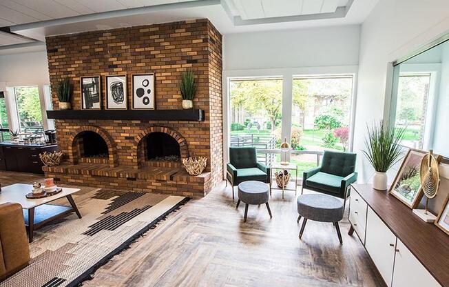 A living room with a brick fireplace and a green chair.