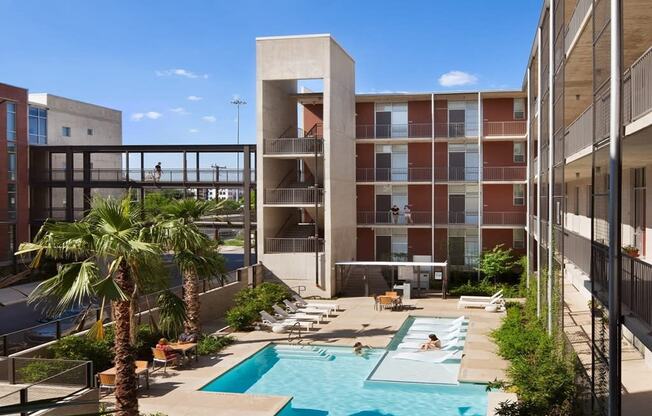 a view of a pool and a building with palm trees