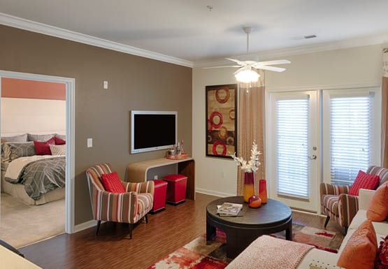 Living room with ceiling fan and door to patio