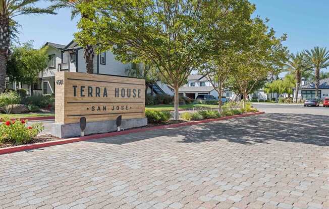 A sign that says Terra House in front of some buildings.