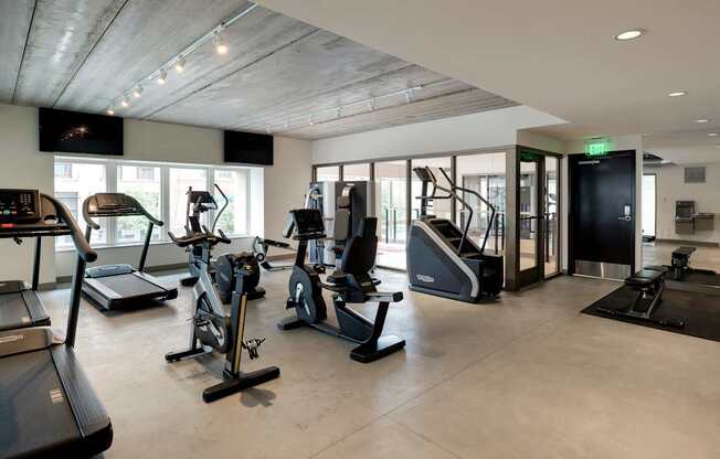 A gym with treadmills, elliptical machines, and other exercise equipment.