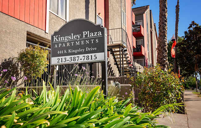 a sign for kingsley plaza apartments in front of a building