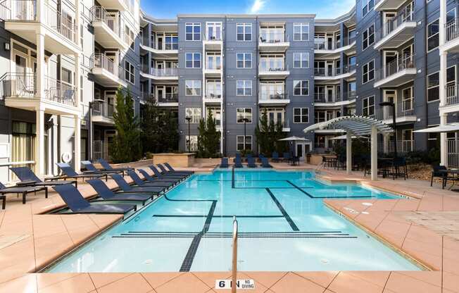 an apartment building with a swimming pool in front of it