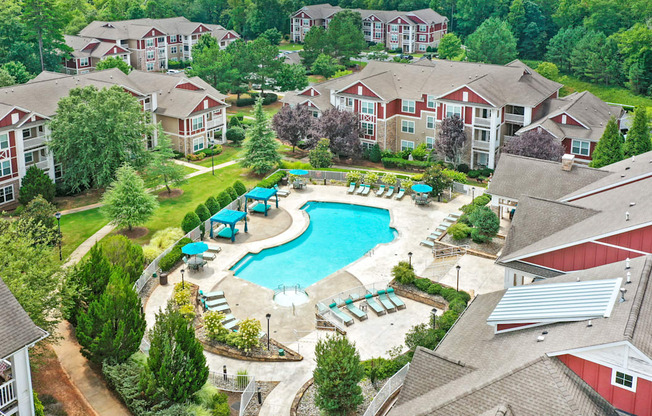 an aerial view of a swimming pool in a community with houses