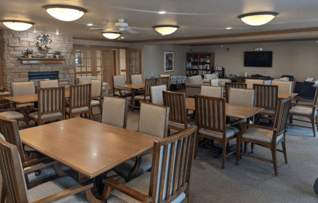 a dining room with tables and chairs and a fireplace