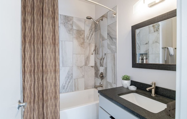 a bathroom with a sink and a shower and a mirror