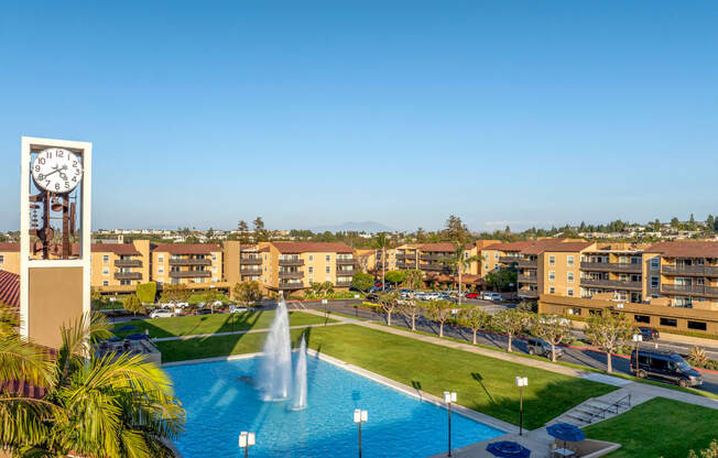 an aerial view of a swimming pool and a clock tower in front of a hotel